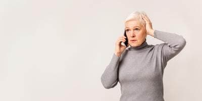 An anxious woman talking on phone who received a scam impersonation call