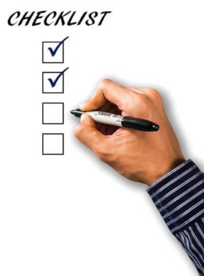 A hand using a marker pen to check boxes on a checklist