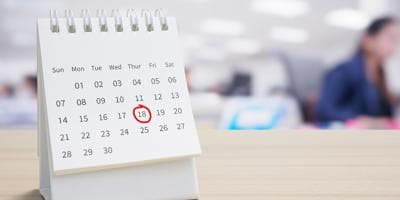 Paper desktop calendar with a circle around the 18th day of the month