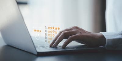 A man using a computer to enter a satisfaction rating