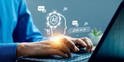 A man typing on his laptop using AI