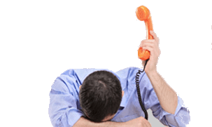 Man with head on desk holding phone in the air