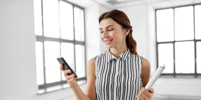 Smiling businesswoman with folder and phone