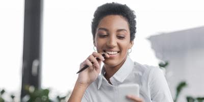 Smiling businesswoman looking at her phone