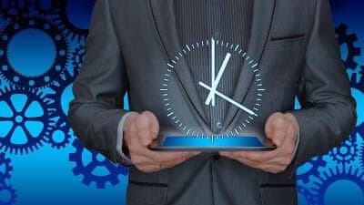 man holding a tablet with a hologram clock floating in the air above it