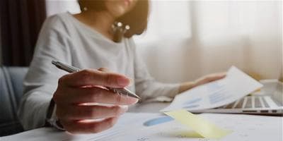 A woman writing notes on a calendar