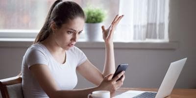 woman looking at mobile phone as a robocall comes in