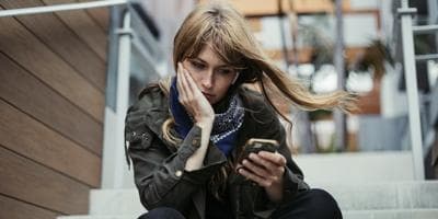 woman looking at phone and waiting