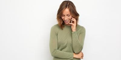 woman talking on phone smiling and looking down